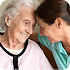 Senior caregiver supporting an elderly woman